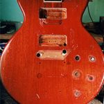 image of electric guitar that has holes on the top