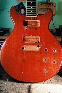 image of electric guitar that has holes on the top