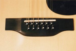 The original bridge and a new compensated saddle on Martin D45