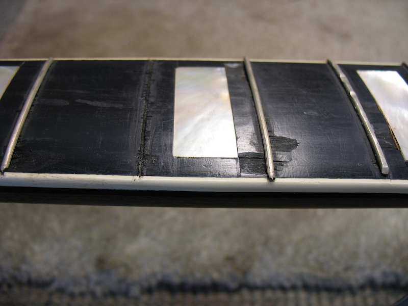 Chipped fretboard of vintage guitar