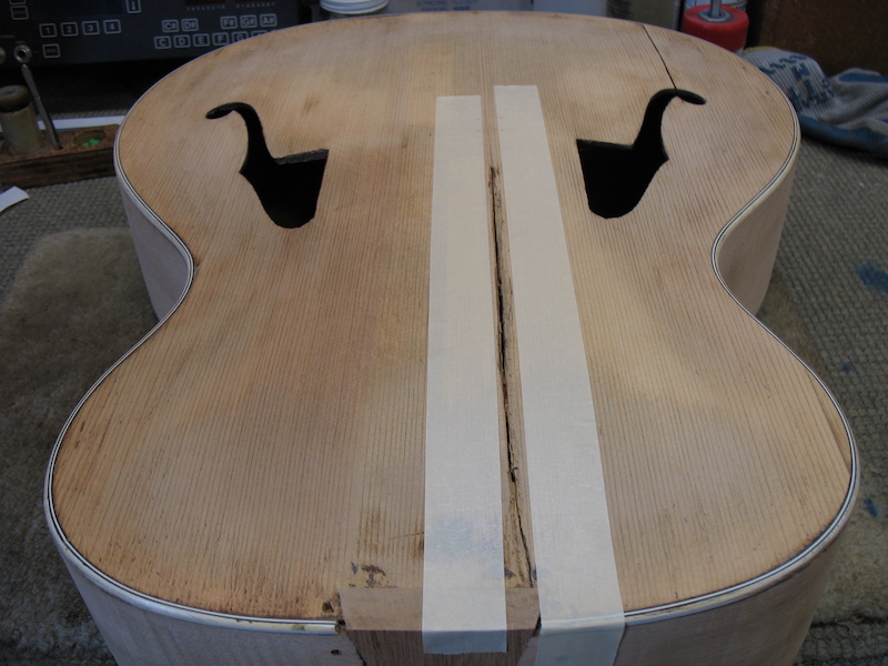 Taping along with the crack on the archtop guitar body