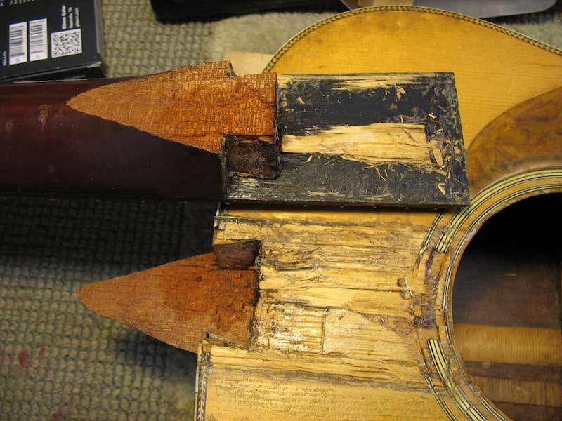 A heel of a vintage parlor guitar is cracked